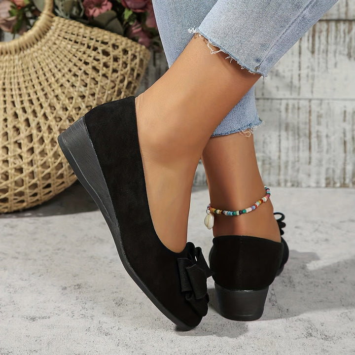 Chic women's footwear, comfortable wedge heel and elegant bow detail.
