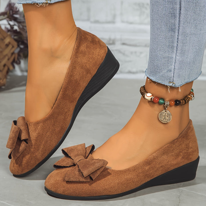 Stylish women's slip-on shoes, subtle wedge heel and elegant bow.