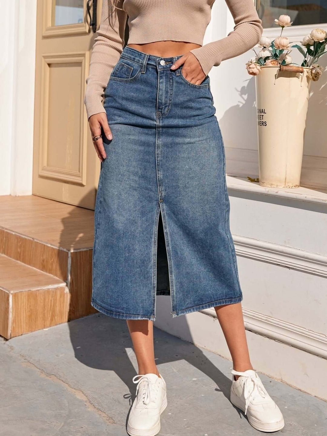 Chic women's high-waisted denim midi skirt with a functional front slit, offering comfort and style.