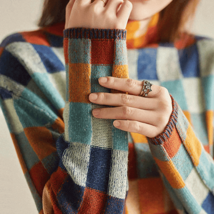 Warm orange patchwork cashmere turtleneck sweater for women, a cozy and stylish knitwear piece.