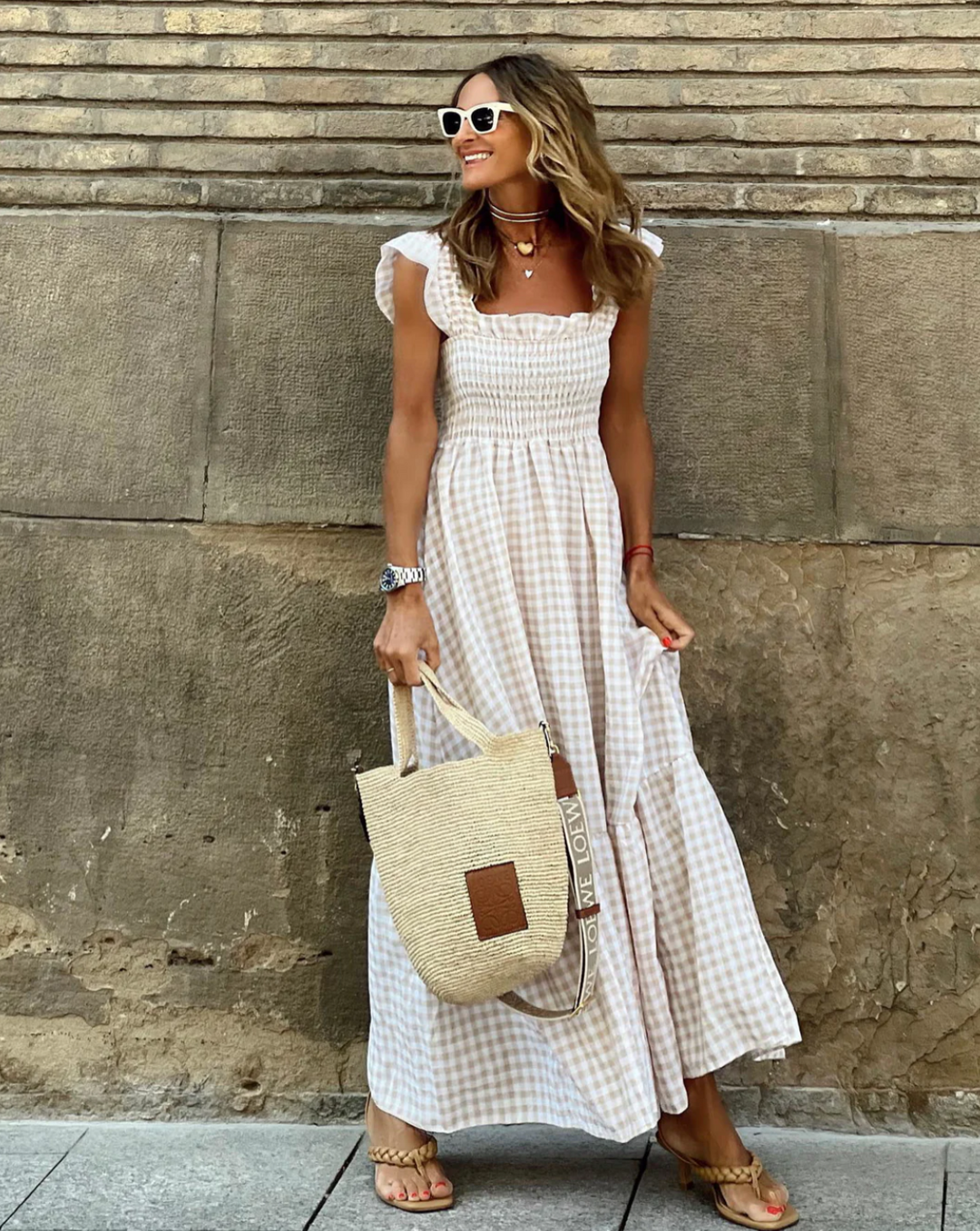 Women's smocked gingham maxi dress with delicate ruffle sleeves, perfect for summer style.