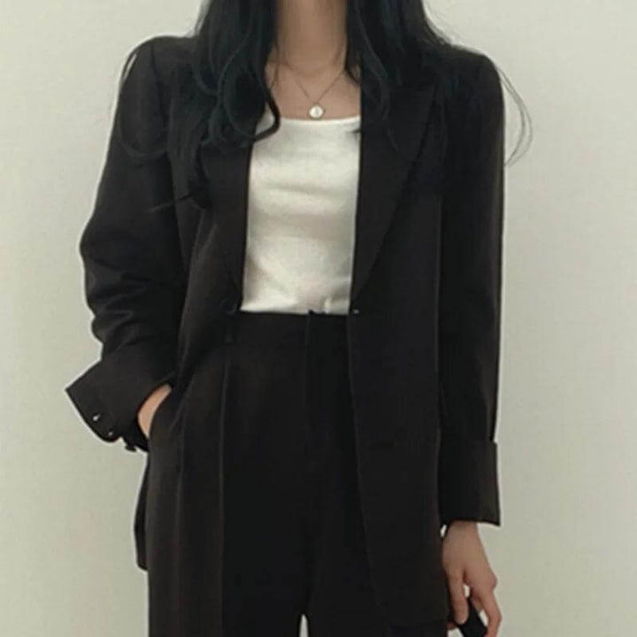 Professional women's attire: tailored blazer and straight-leg pants set, elegant & smart.