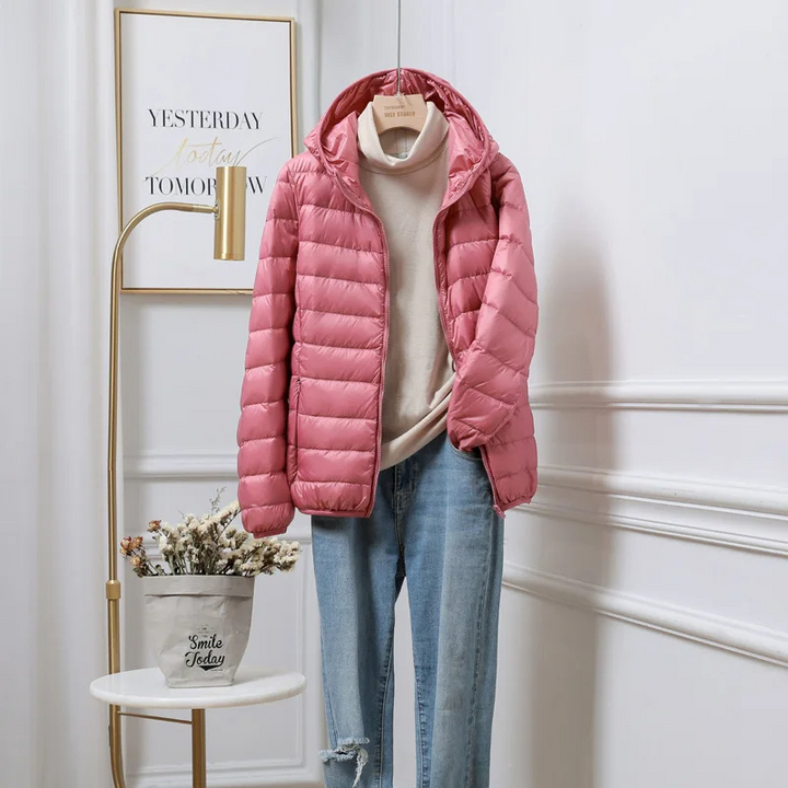 Warm women's ultralight puffer jacket with hood, ideal for winter adventures & casual wear.