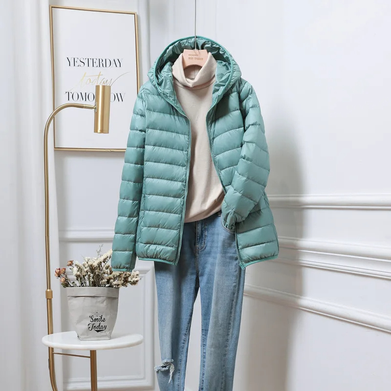 Folded ultralight women's hooded puffer jacket, compact & ready for travel essentials.