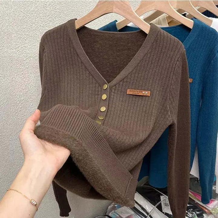 Textured women's V-neck knitted jumper, offering comfort and warmth. A stylish long-sleeve sweater for cooler weather.