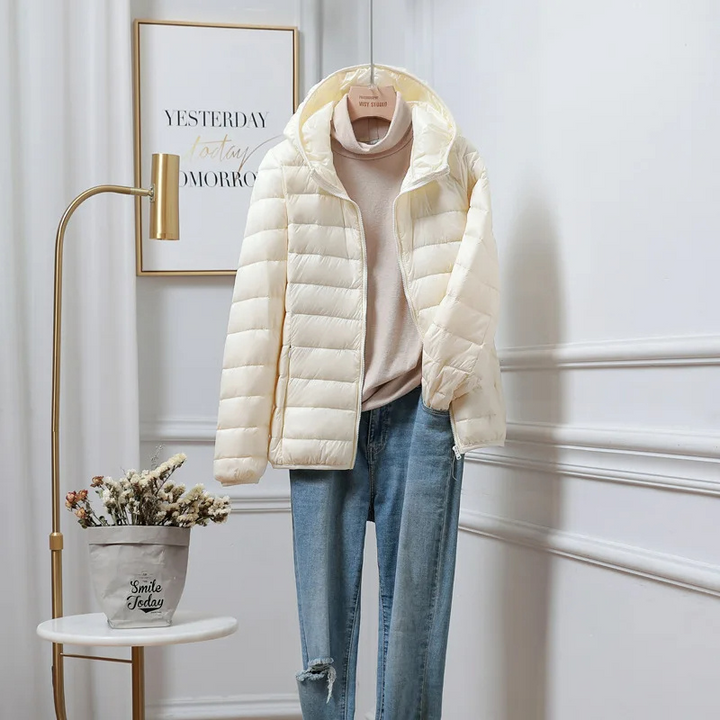 Insulated women's puffer jacket with a cozy hood & zip closure for winter warmth.