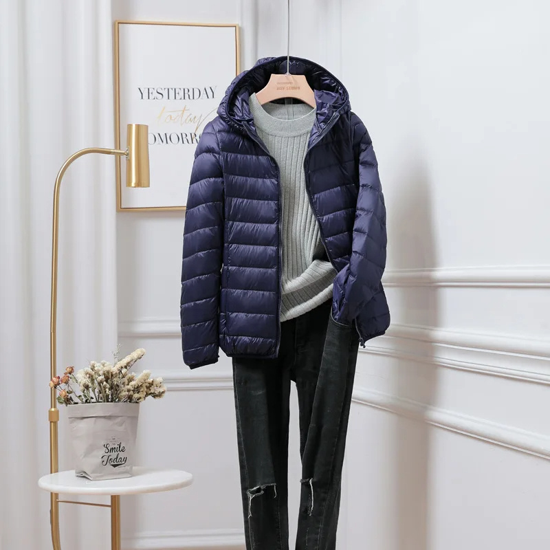 Stylish women's zip-up puffer jacket with a comfortable hood, great for everyday cold wear.