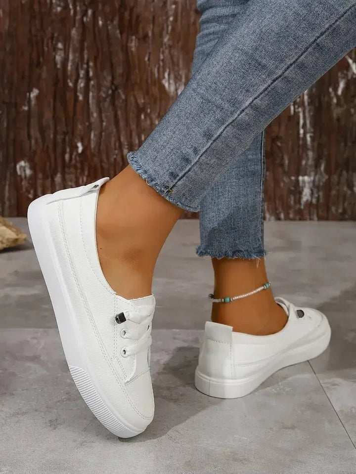 Essential women's white casual flat sneakers with lace-up closure, offering comfort and style for everyday use.