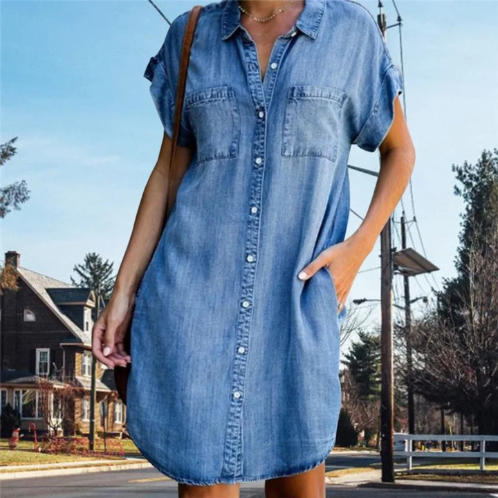 Women's denim short sleeve shirt dress with button-down front, relaxed fit, and chest pockets for a casual yet elegant look.